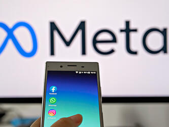 Meta logo and phone with Meta apps